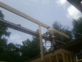 Carpenter setting a ridge beam over a new addition frame — Ice Dam Removal by Roofing Brothers in Chestnut Ridge