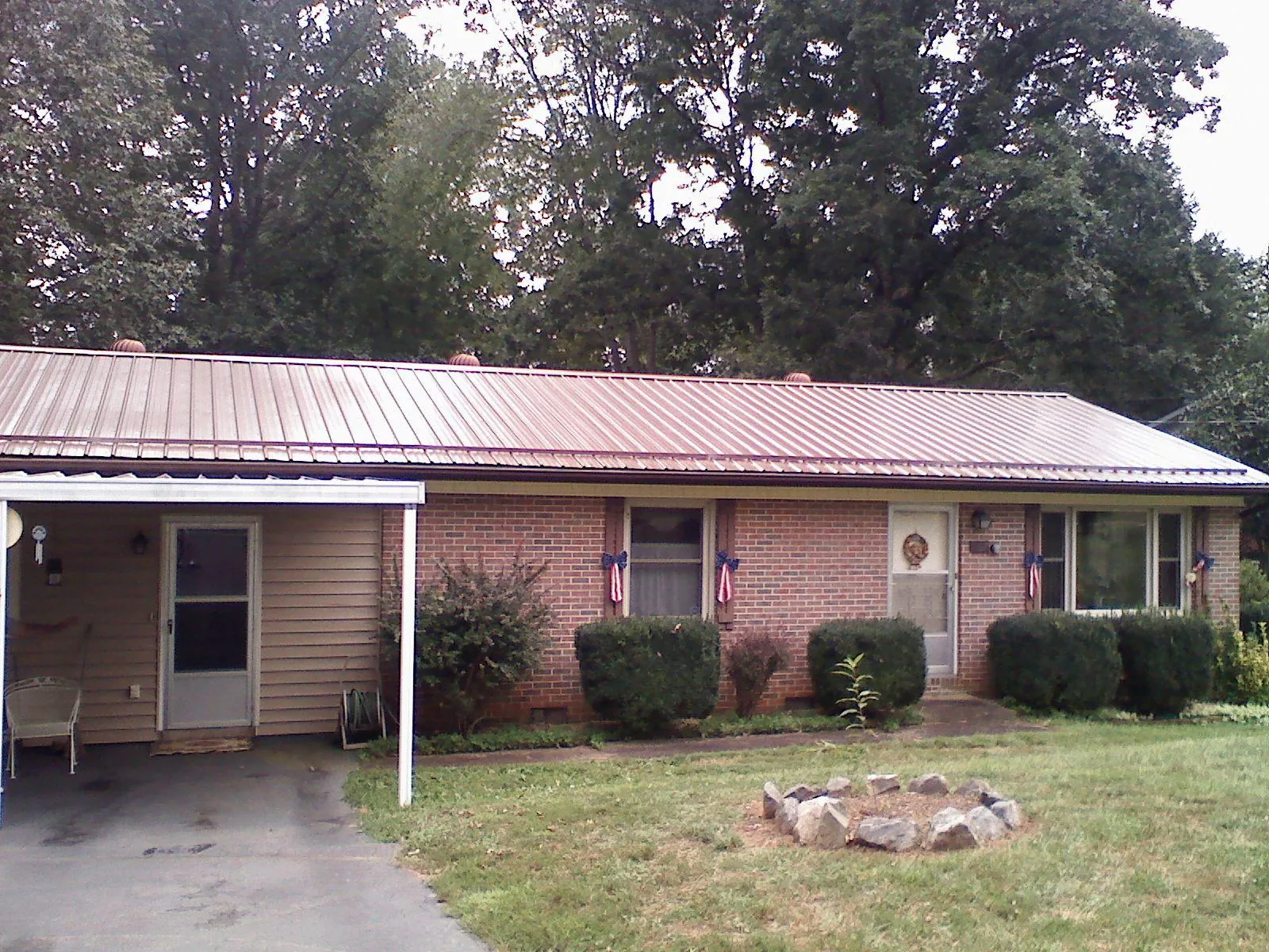 Bronze metal roof and carport on a brick ranch home — Roof Repair work by our crew in Chestnut Ridge